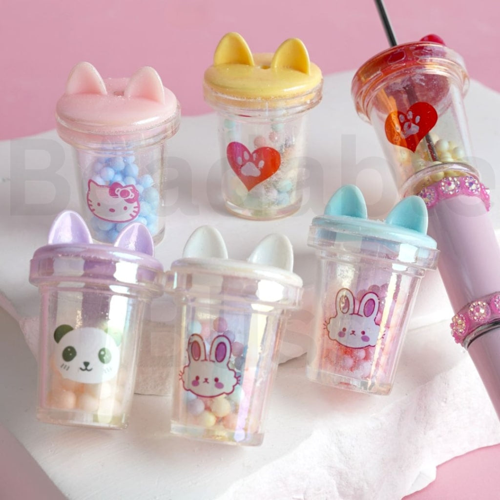 Set of cute, cartoon-themed cups with animal designs on a pink background

