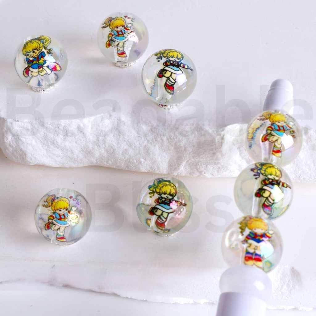Set of glass beads with cartoon character designs on a white background

