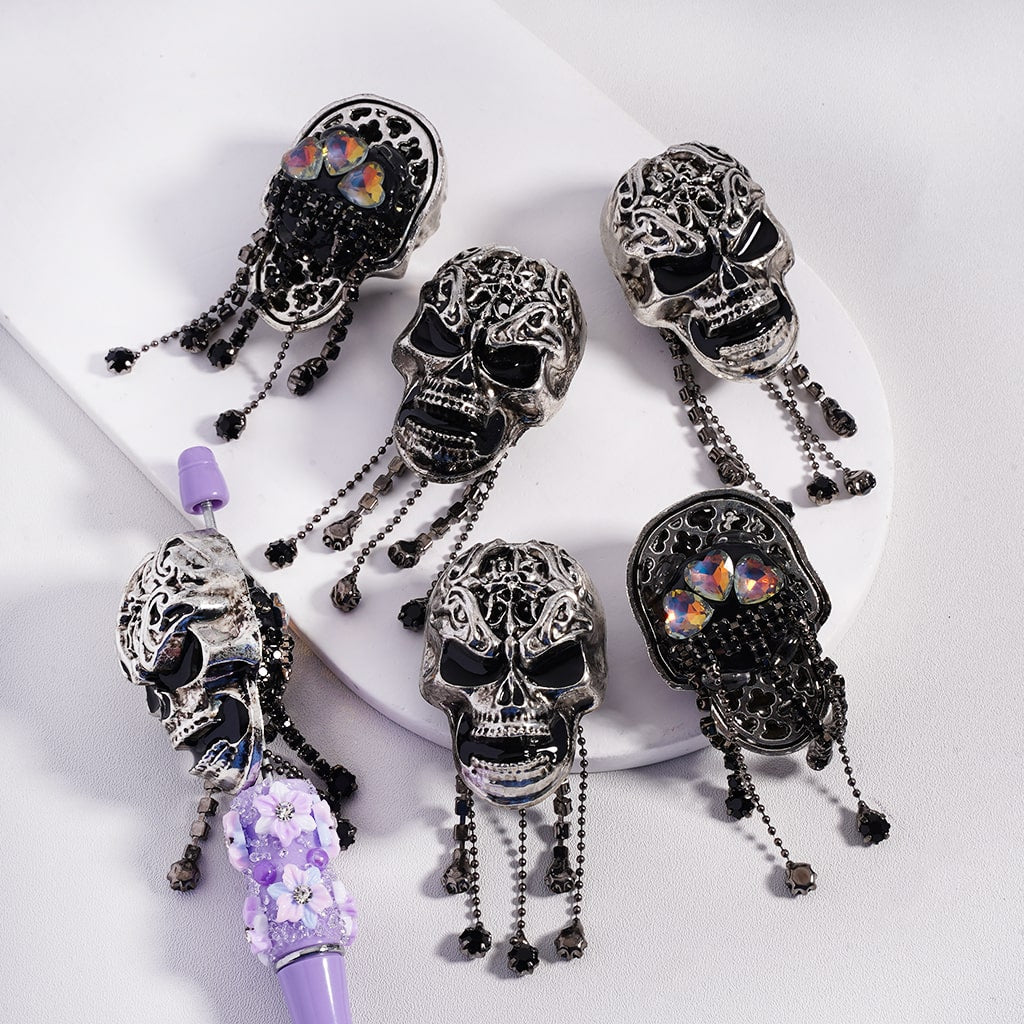Decorative skull-shaped hair accessories with purple accents on a white background

