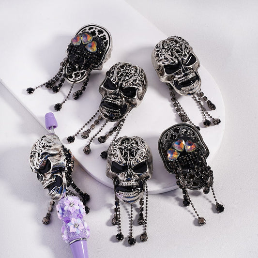 Decorative skull-shaped hair accessories with purple accents on a white background


