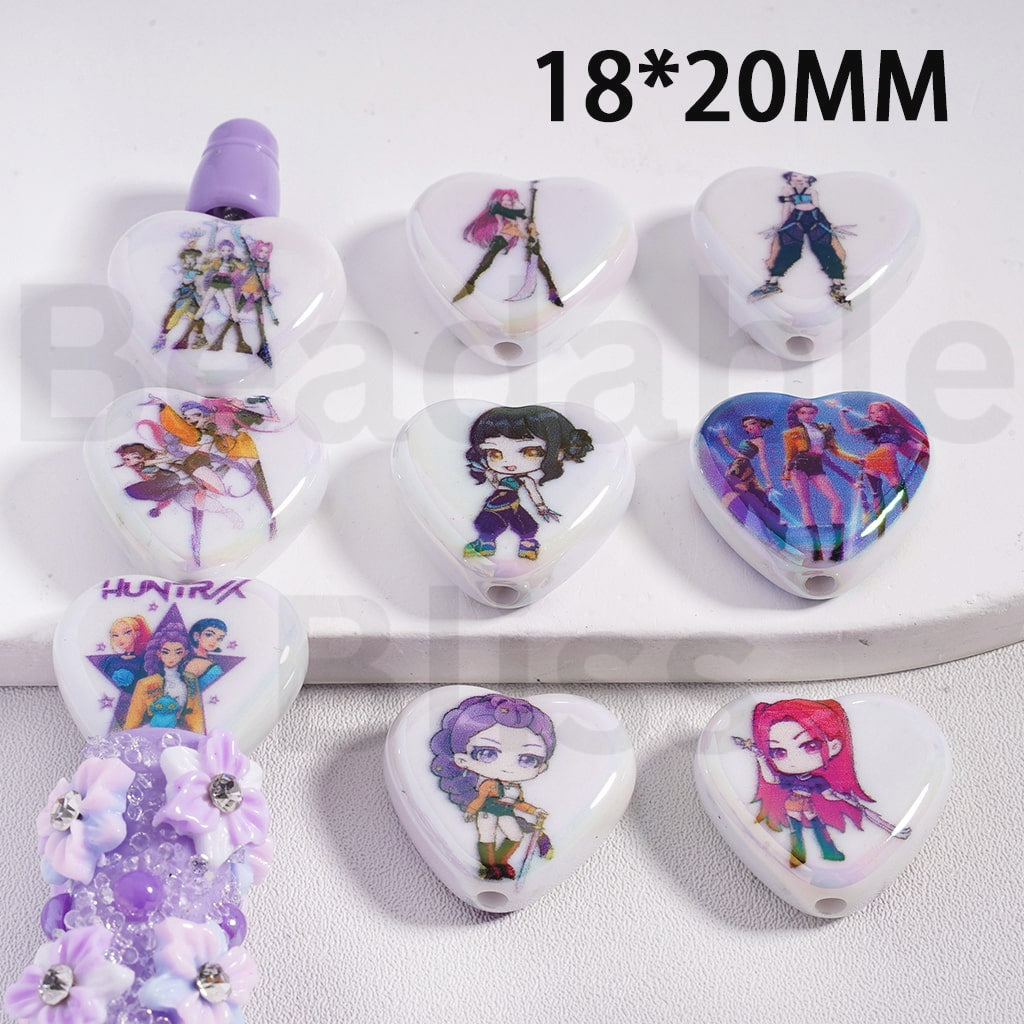 Heart-shaped pendants with animated character designs on a white surface.

