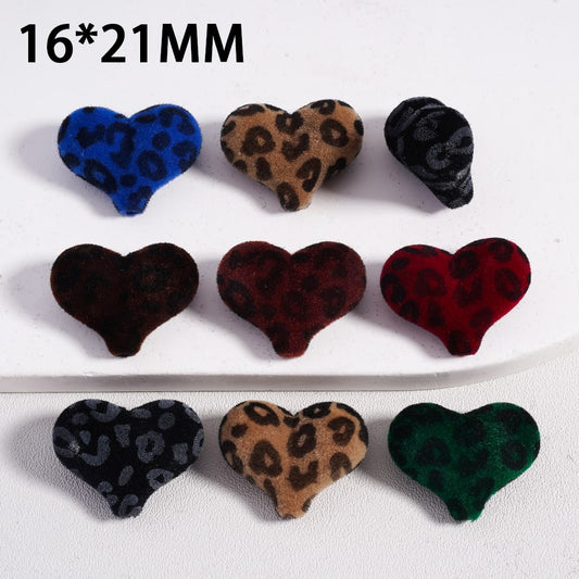 Heart-shaped buttons with leopard print pattern in various colors on a white background.

