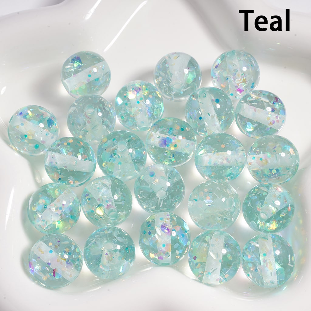 Teal beads with glitter on a white plate

