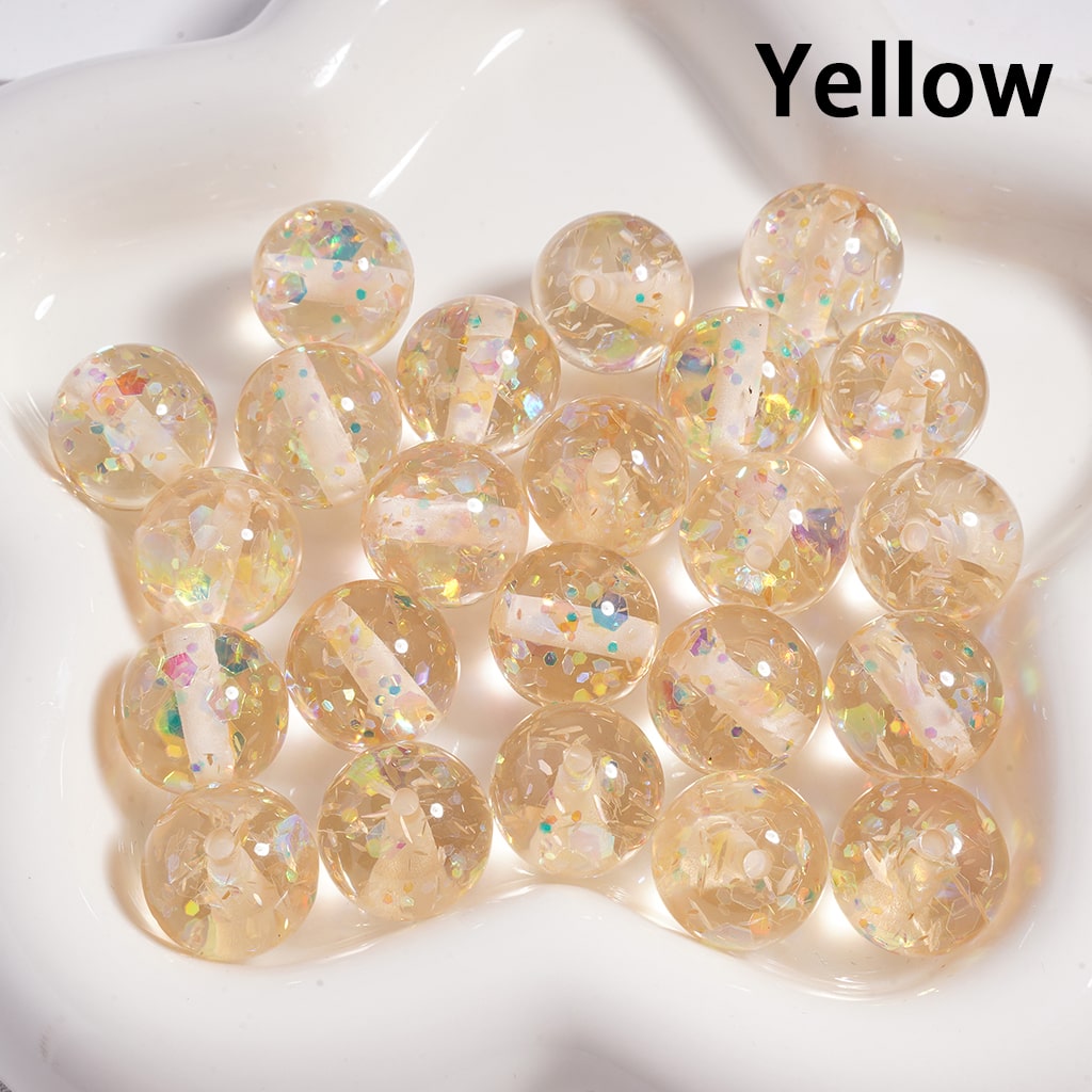 Yellow marbles with glitter on a white surface

