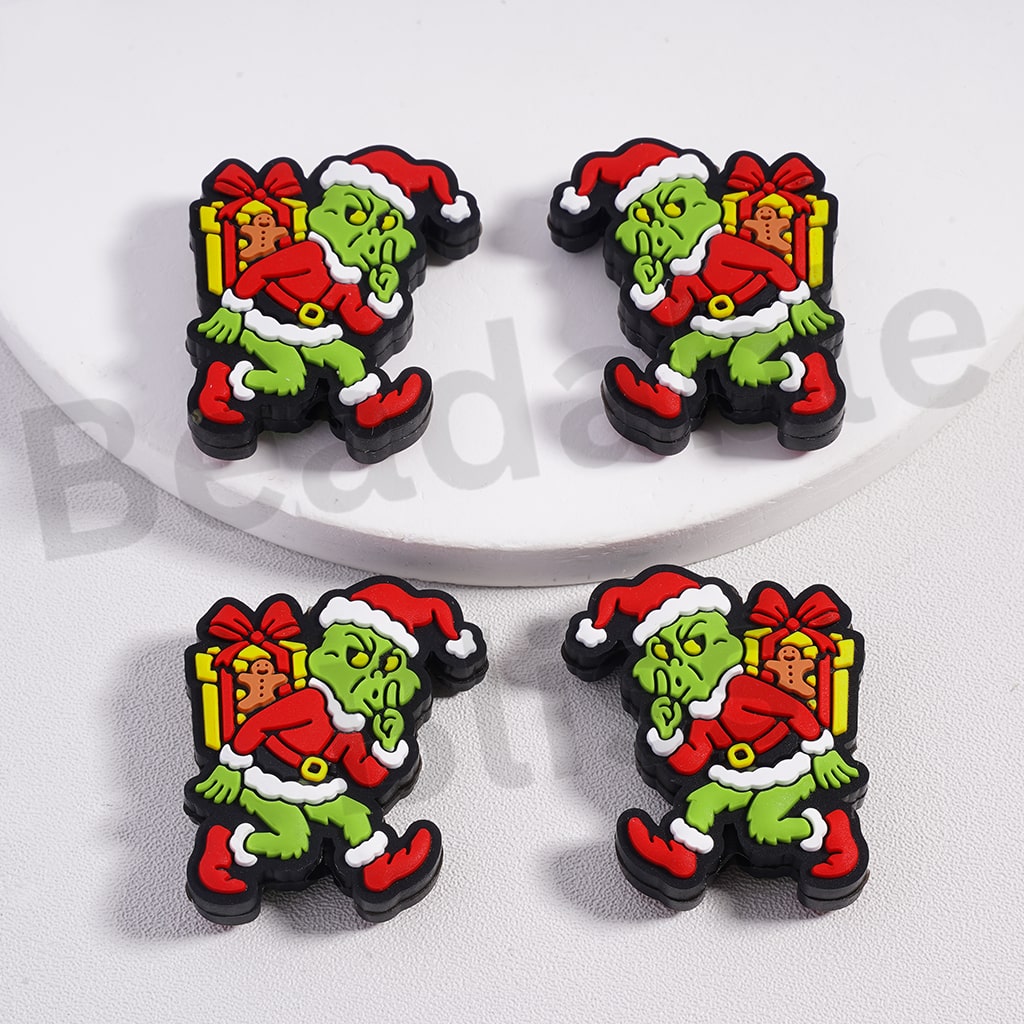Four Christmas-themed figurines with a green character in a red suit on a white background.

