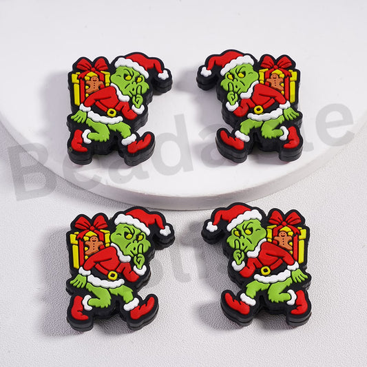 Four Christmas-themed figurines with a green character in a red suit on a white background.

