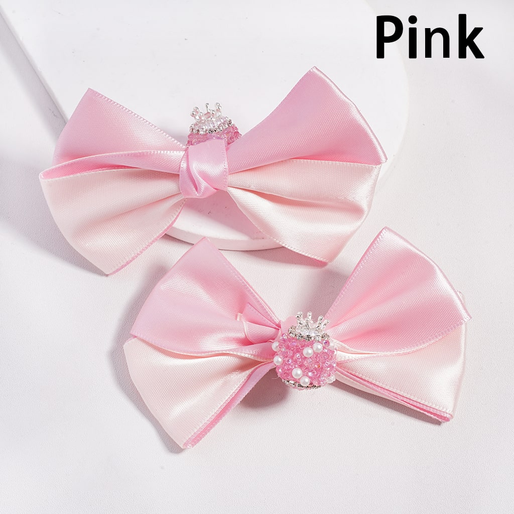 Two pink satin bows with decorative centers on a light gray background.

