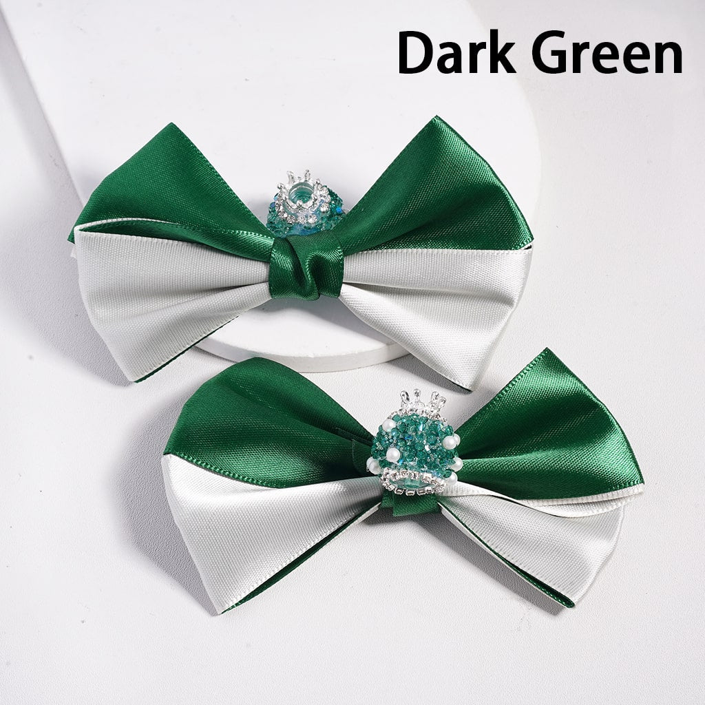Two dark green and white bow ties with decorative elements on a light gray background.


