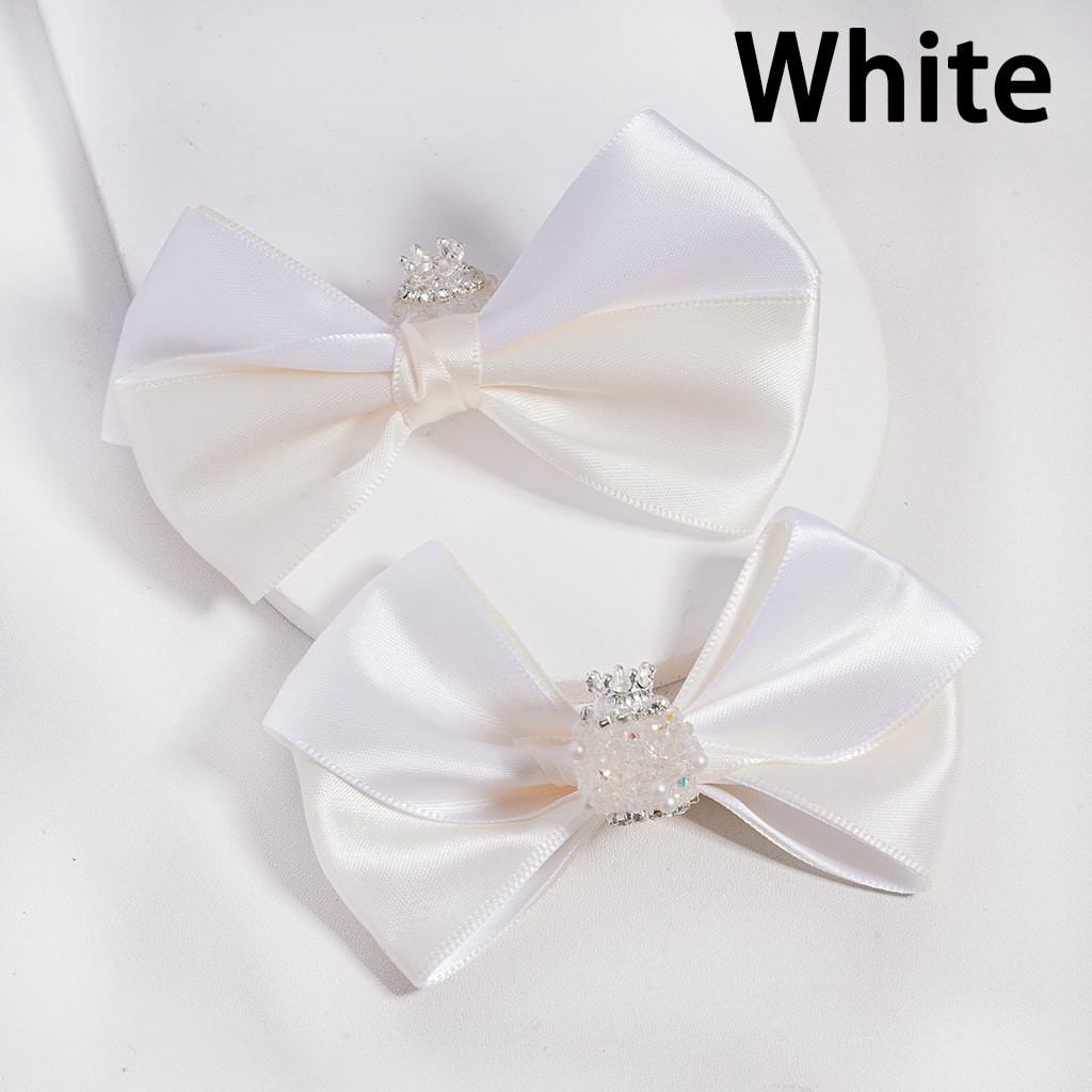Two white satin bows with crystal centers on a light gray background.

