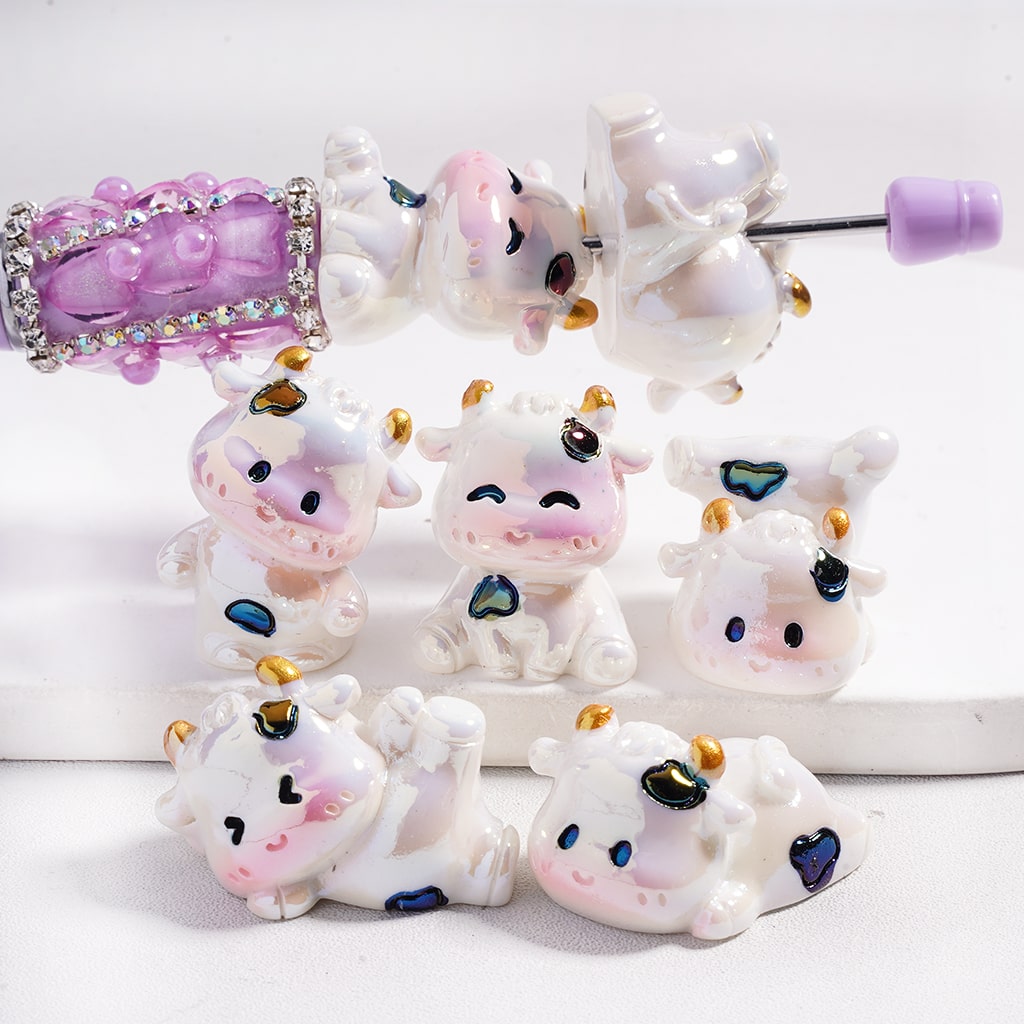 Set of cute cow-shaped hair accessories with pink and purple accents on a white background
