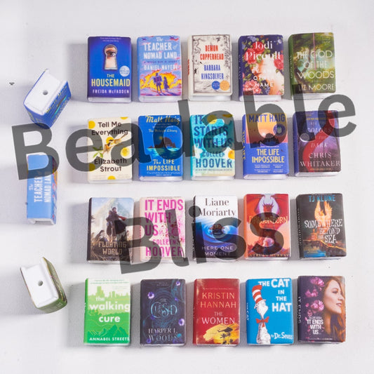 Collection of books displayed on a white wall with a visible brand logo.
