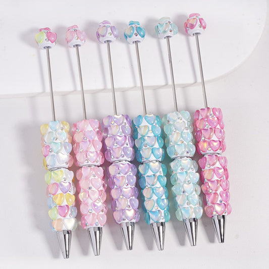 Set of colorful pens with heart-shaped designs on a white background