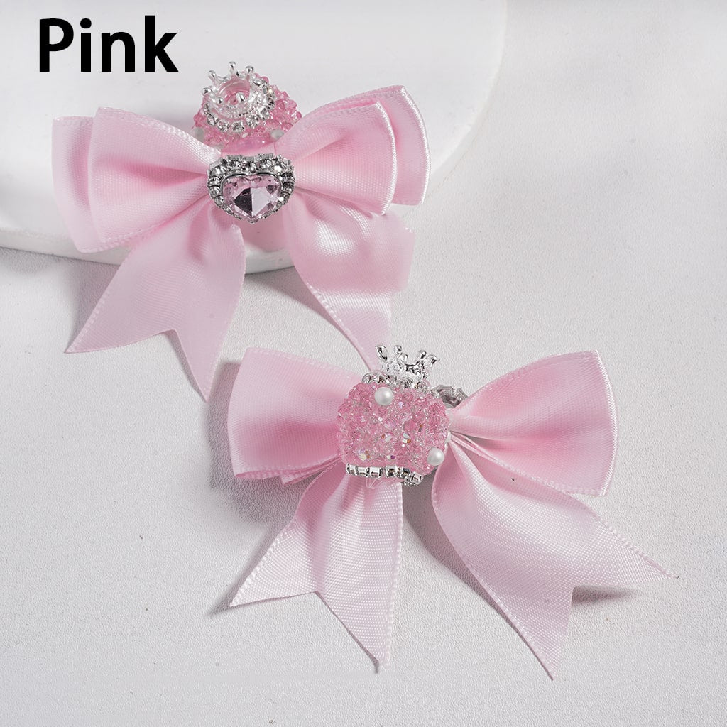 Two pink satin hair bows with decorative centers on a white background.

