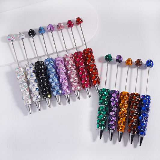 Set of colorful beaded pen toppers on a white background