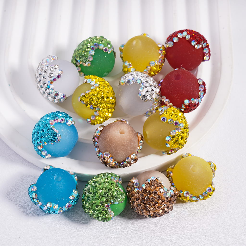 Colorful beads with rhinestones on a white plate