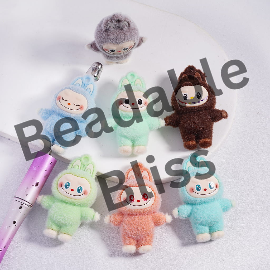 Small plush toys in various colors with a pen on a white background, labeled '35*48mm'.

