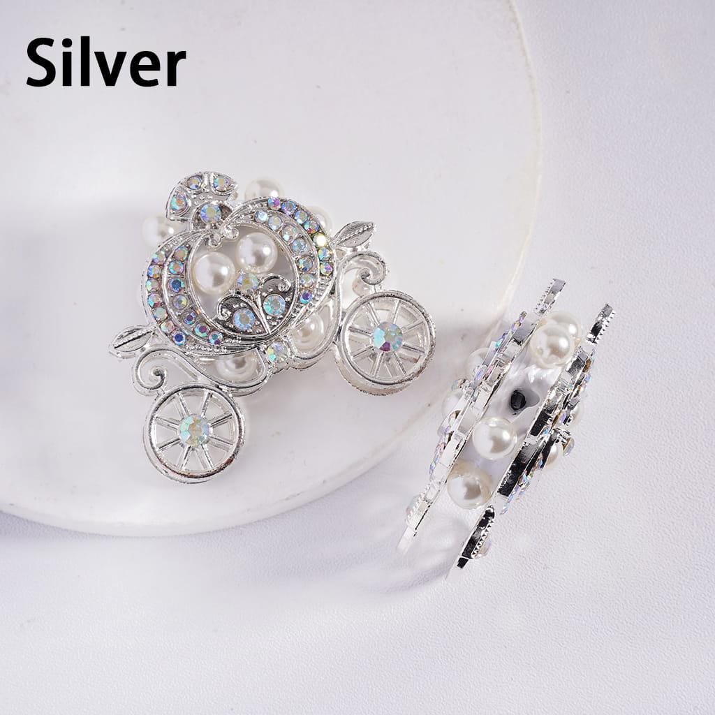 Silver carriage-shaped brooch with pearls on a white background