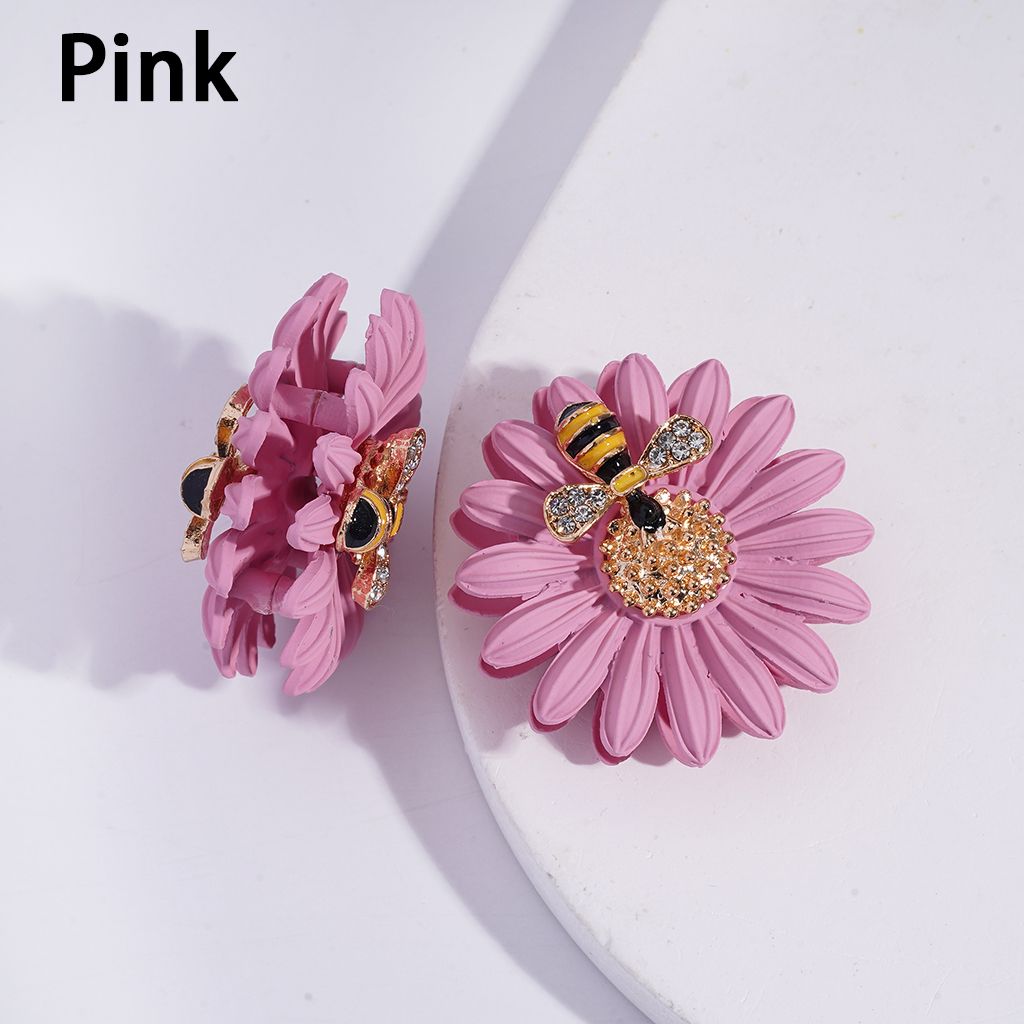 Pink flower earrings with bee embellishments on a white background