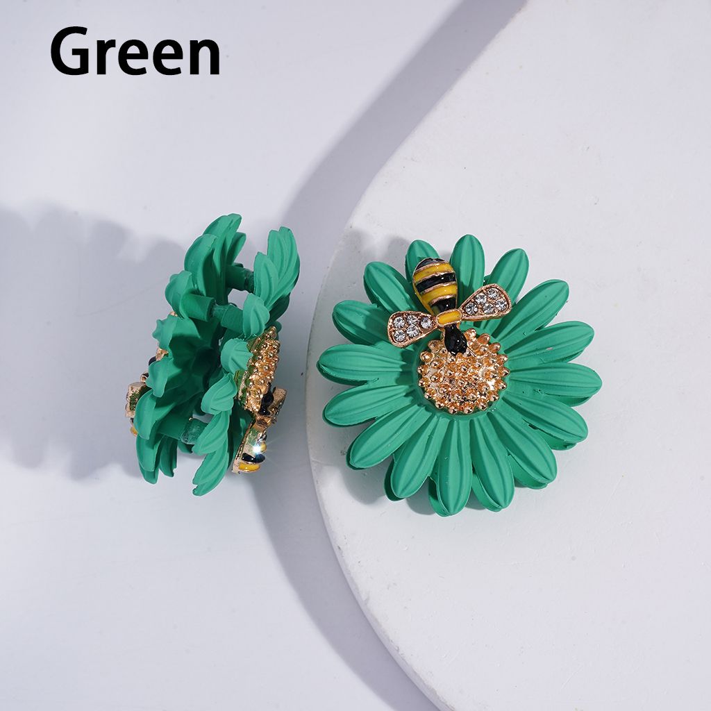 Green floral earrings with bee accents on a white background