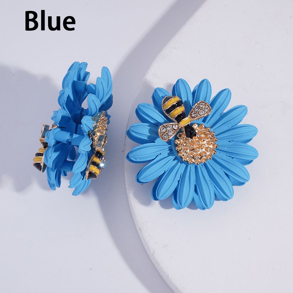Blue flower earrings with bee design on a white background