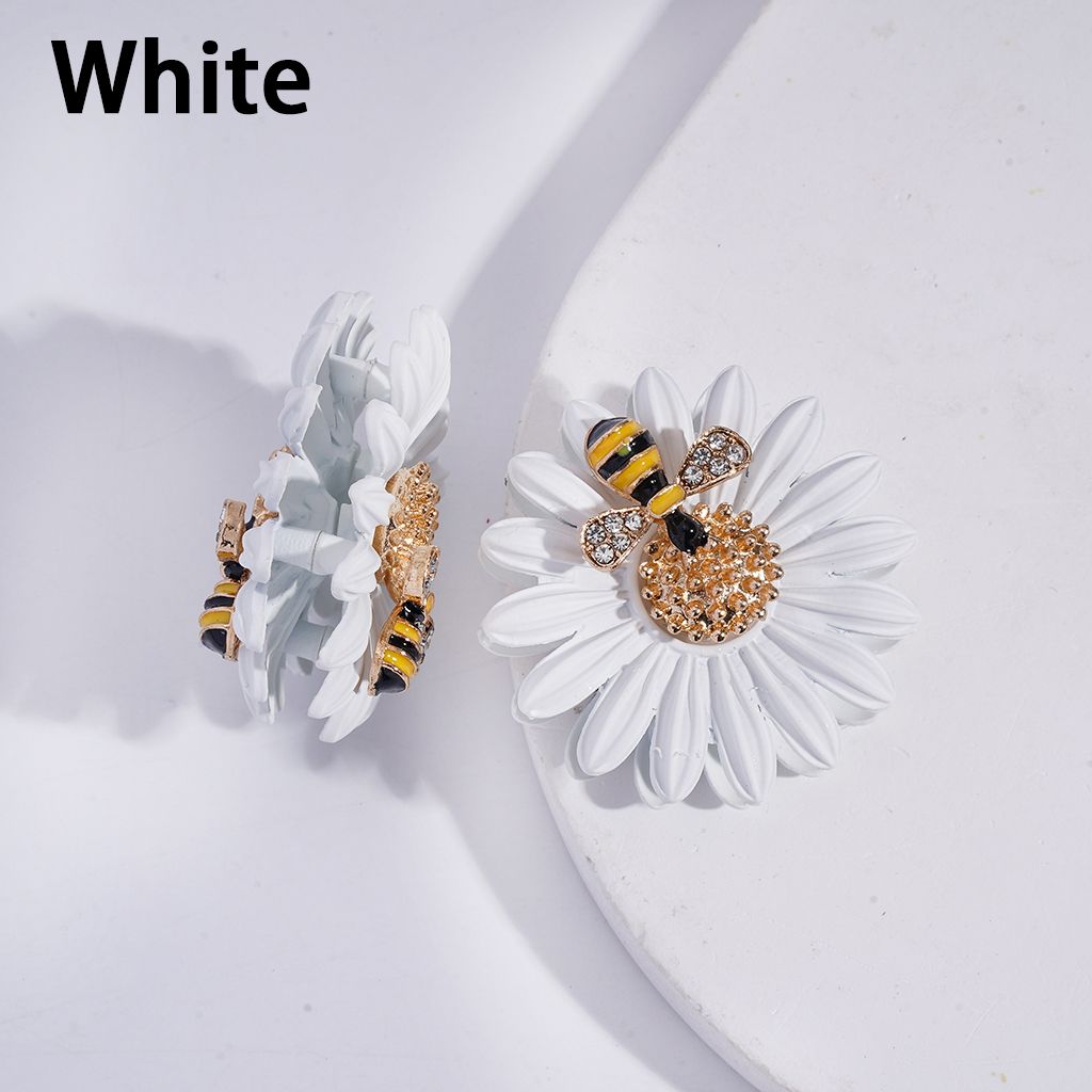 White earrings with bee and flower design on a white background