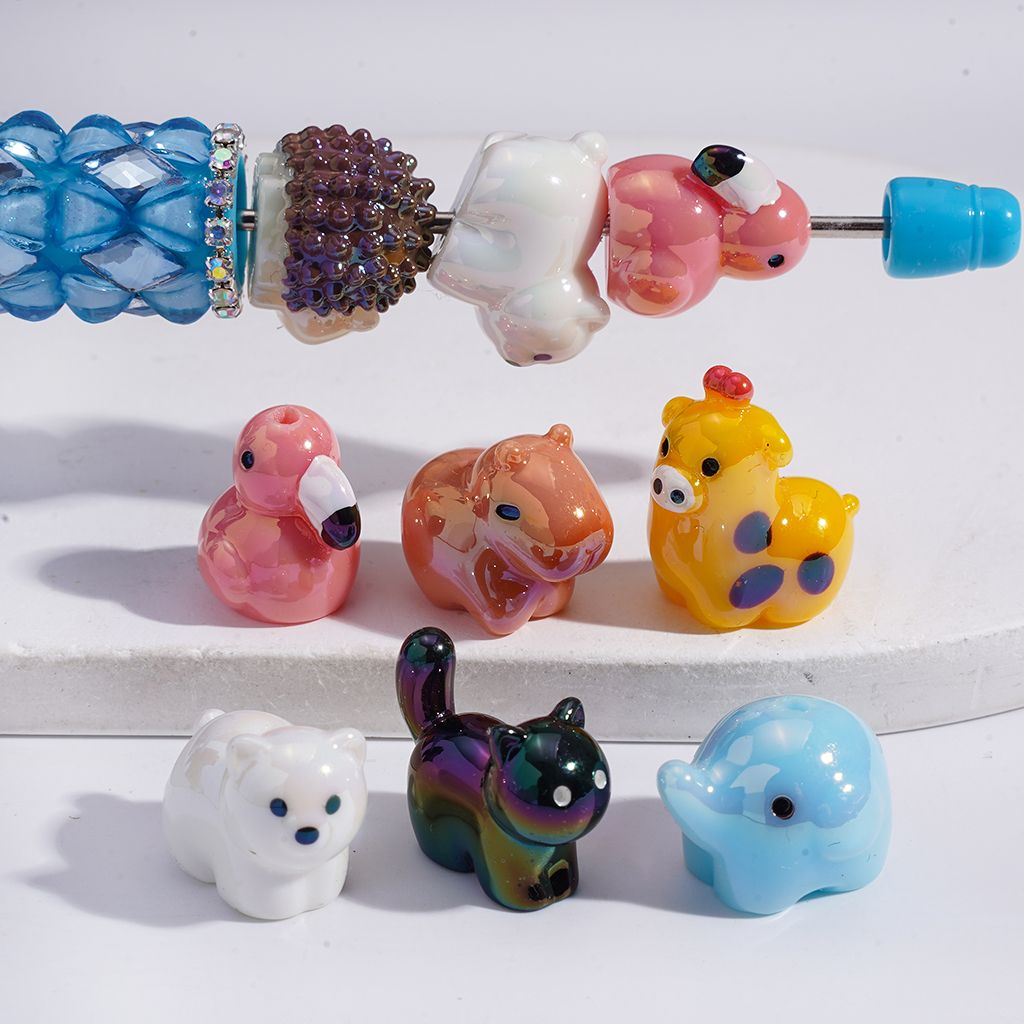 Colorful glass beads shaped like animals on a white background