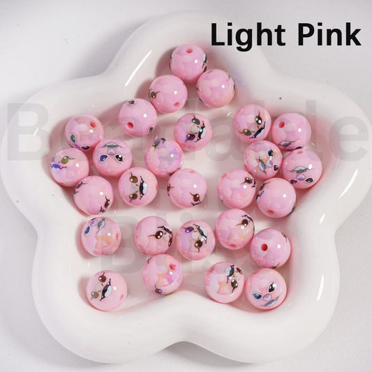 Light pink beads with small decorative figures on a white dish, labeled 'Light Pink'.

