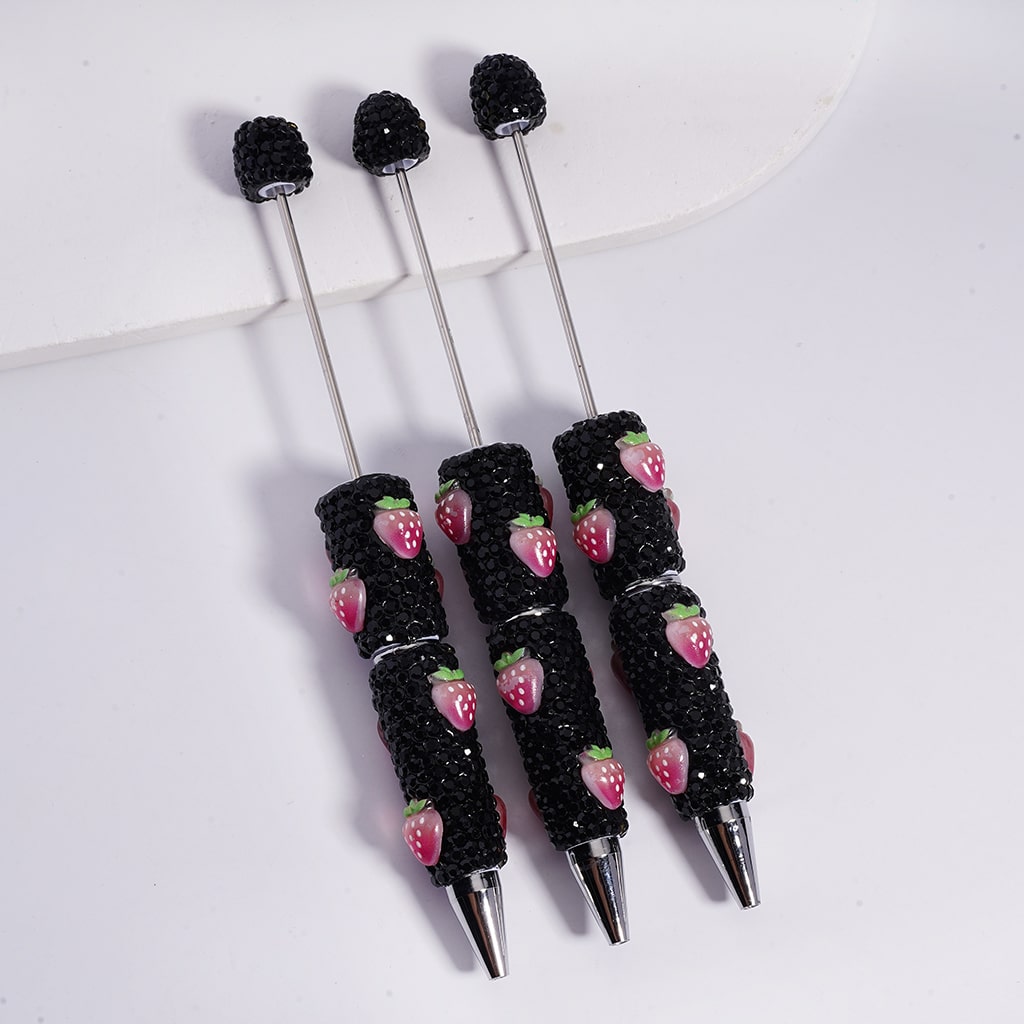 Set of black pens with strawberry patterns on a white background


