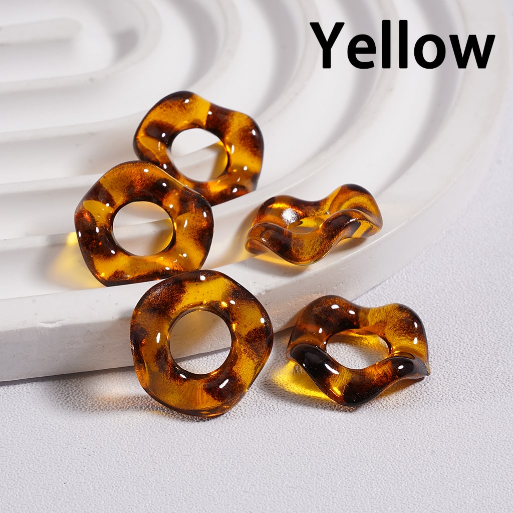 Yellow tortoiseshell earrings on a textured white surface

