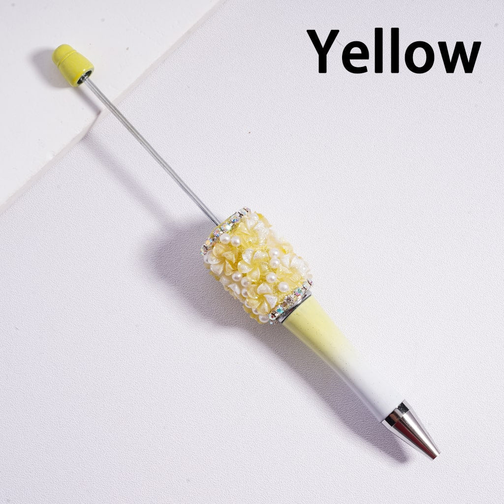 Yellow pen with decorative top on a white background

