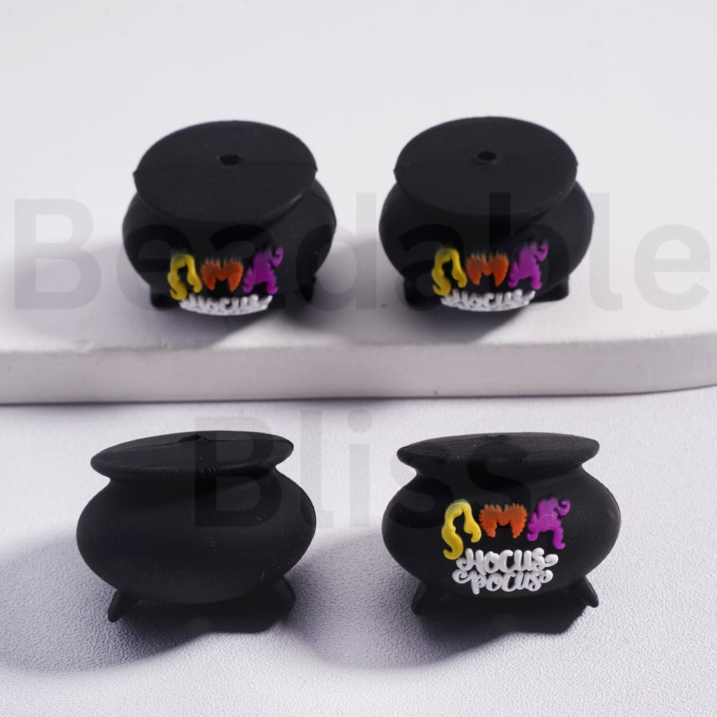 Four black pots with colorful designs on a white background


