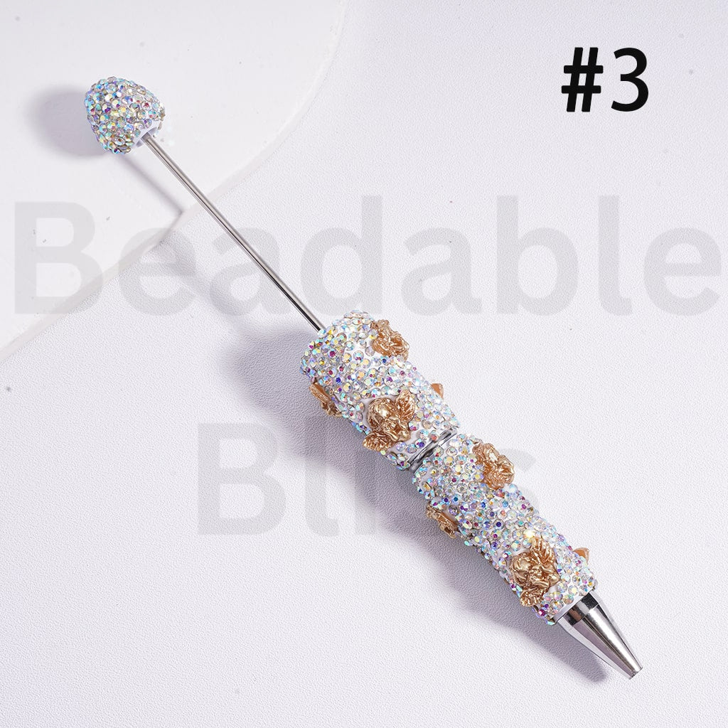 Decorative pen with gemstones on a white background, branded 'beadbablebliss'.

