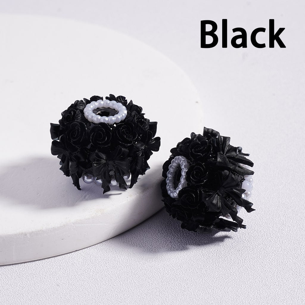 Black floral earrings on a white surface with 'Black' text above.

