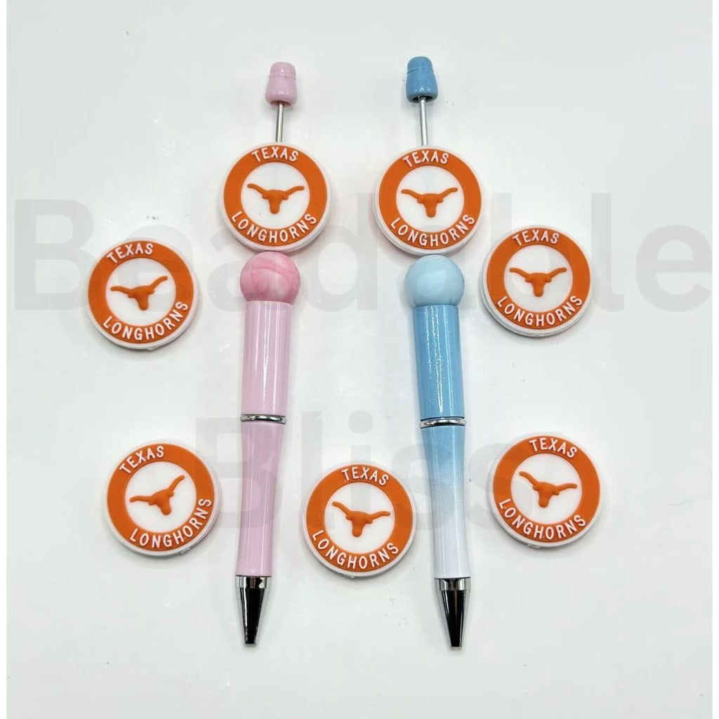 Two pens with Texas Longhorns logos on a white background, one pink and one blue.

