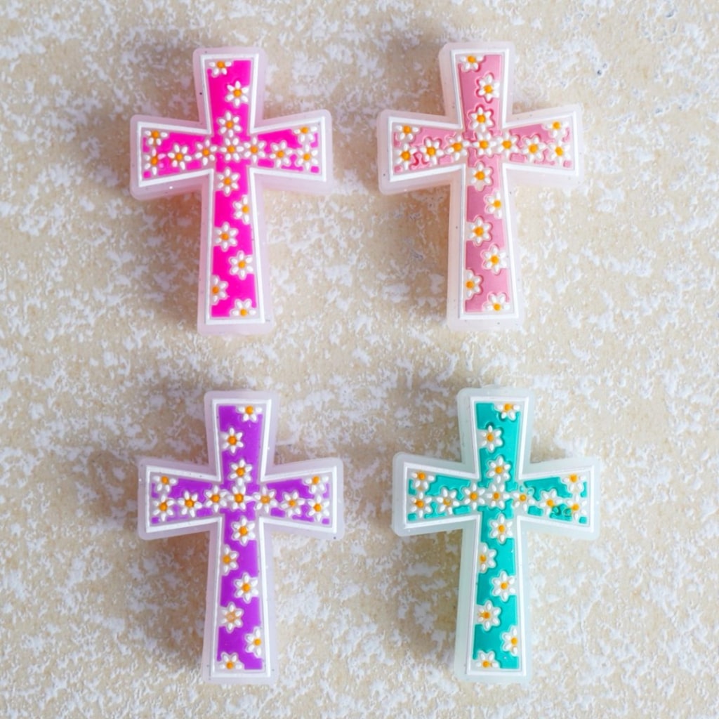A set of silicone beads in the shape of crosses, adorned with colorful, mini cute flowers.

