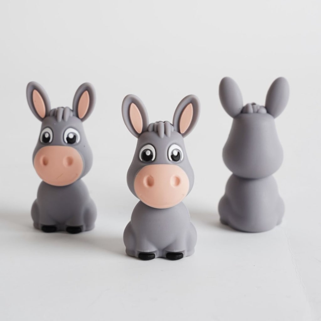 Three donkey figurines of different poses on a white background

