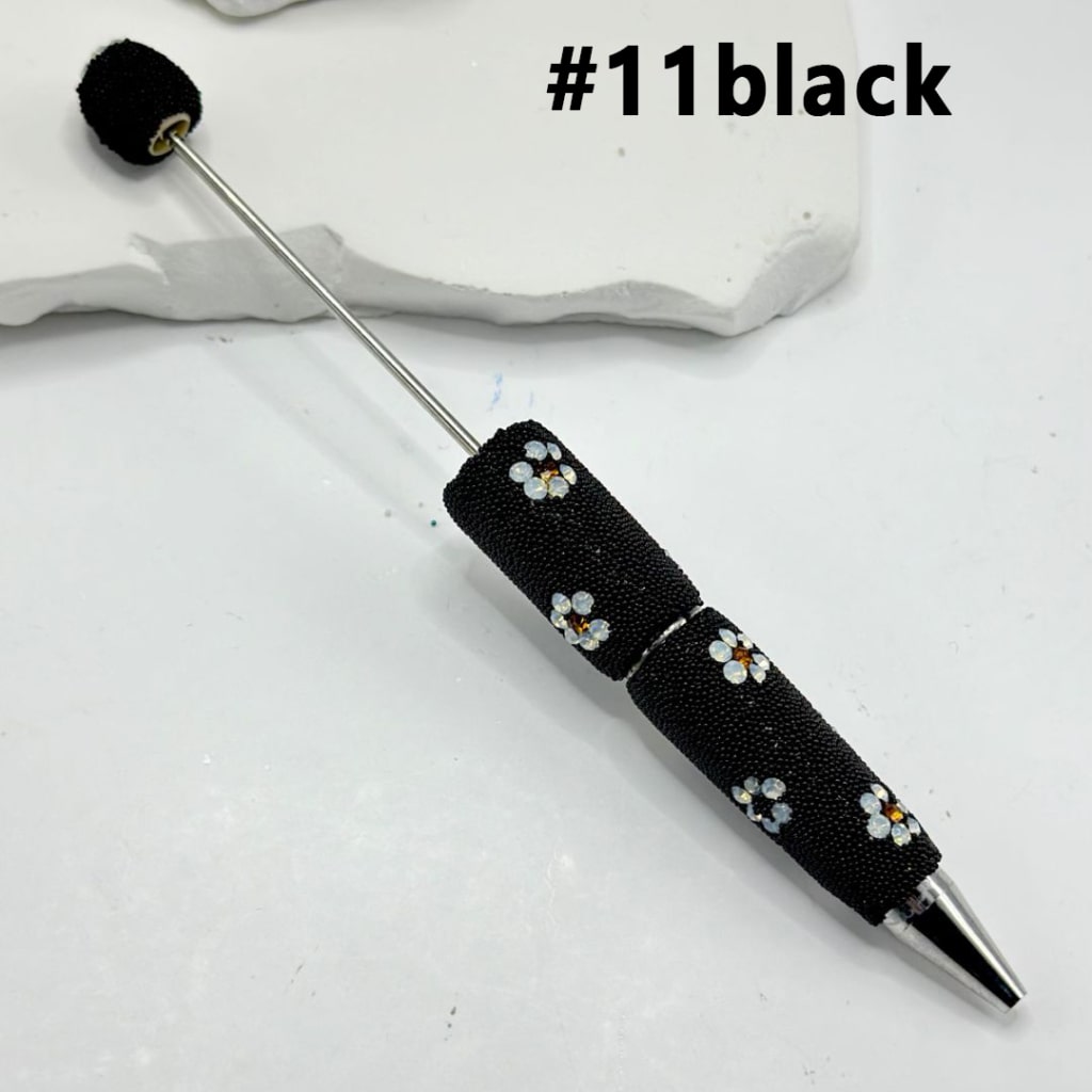 Black pen with floral design on a white background

