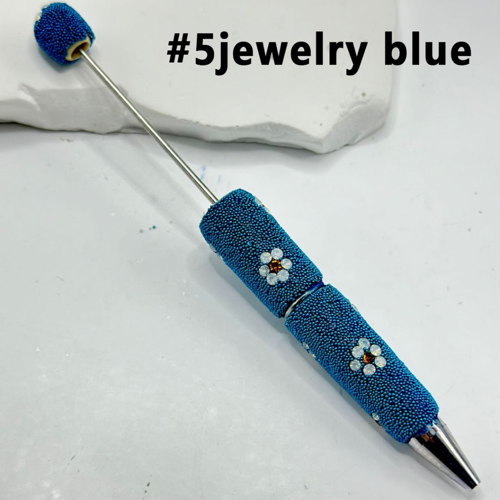 Blue textured pen with decorative elements on a light gray background, labeled '#5jewelry blue'.

