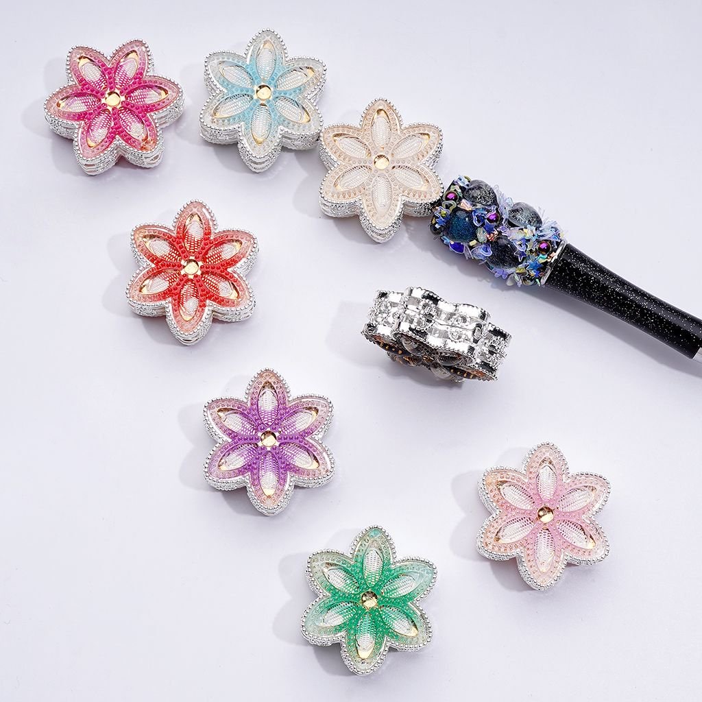 A collection of silver-colored alloy flower beads with vibrant rhinestones in various colors including pink, blue, green, and purple.

