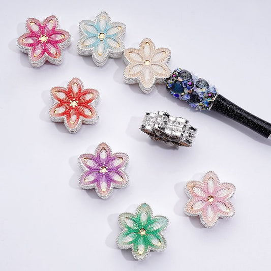 A collection of silver-colored alloy flower beads with vibrant rhinestones in various colors including pink, blue, green, and purple.

