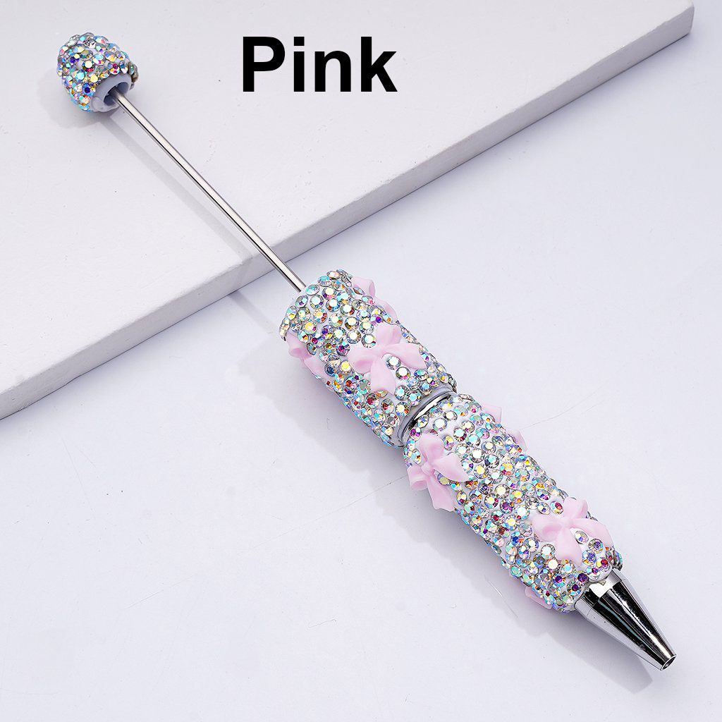 Decorative pen with pink accents and rhinestones on a white background

