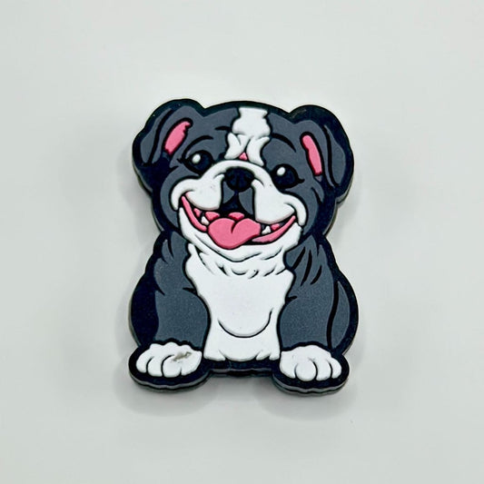 A silicone bead in the shape of a cartoon-style pug dog with black, white, and gray colors.

