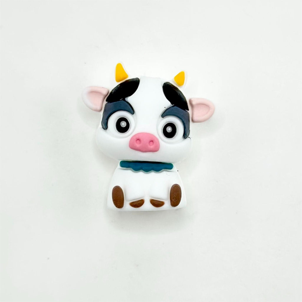 A silicone focal bead featuring a combination of a piggie and a calf cow design.

