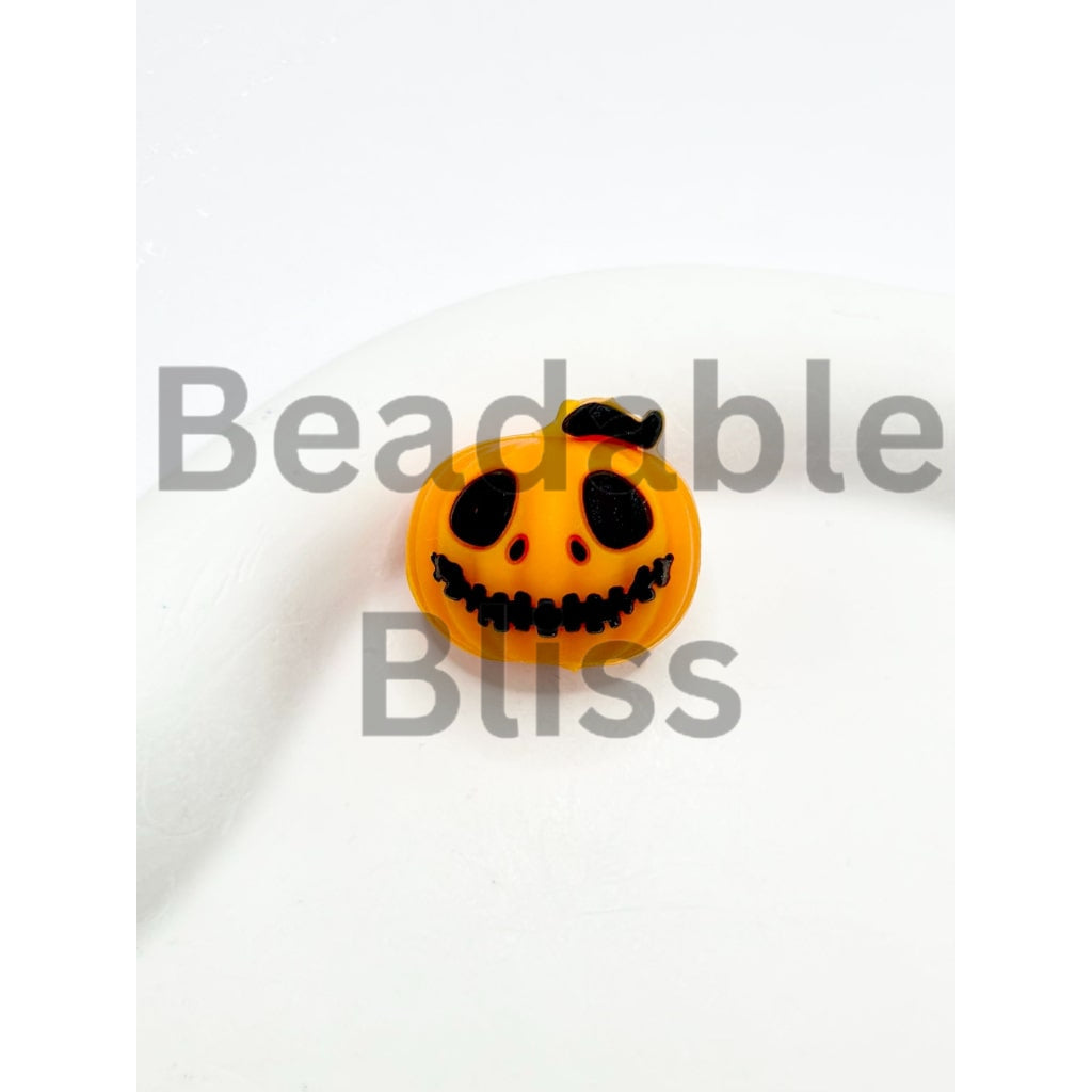 Small pumpkin-shaped toy with a face on a white background

