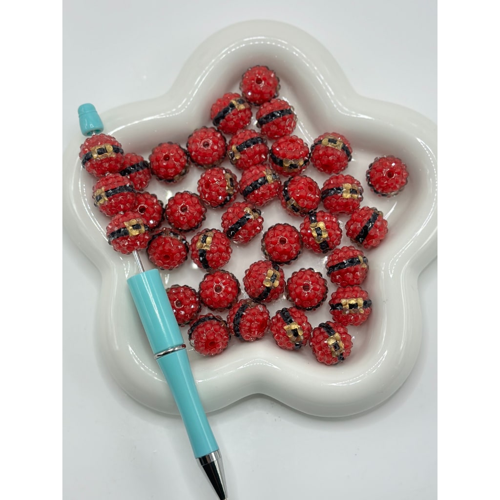 Star-shaped dish with red beads and a blue pen on a white background

