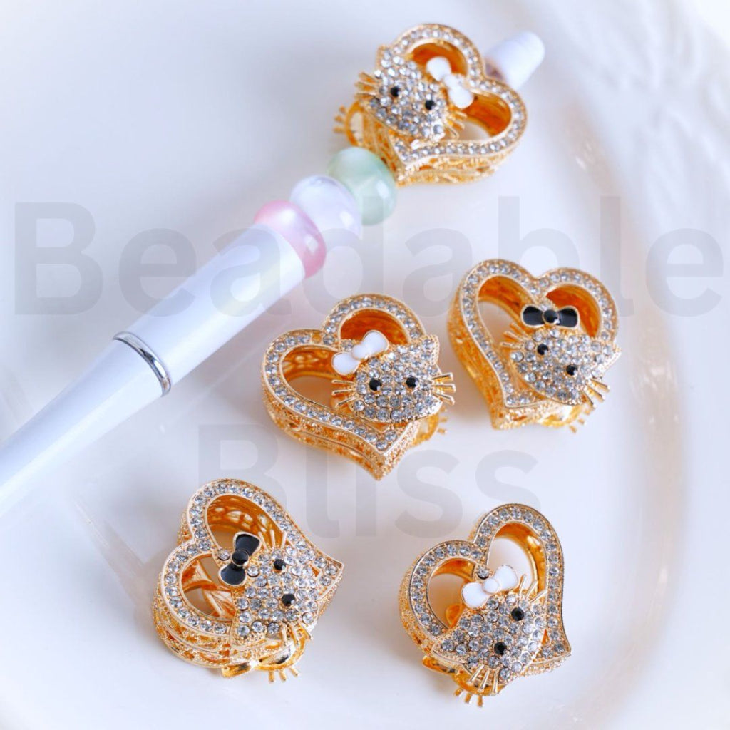 Gold heart-shaped earrings with crystal details on a white background

